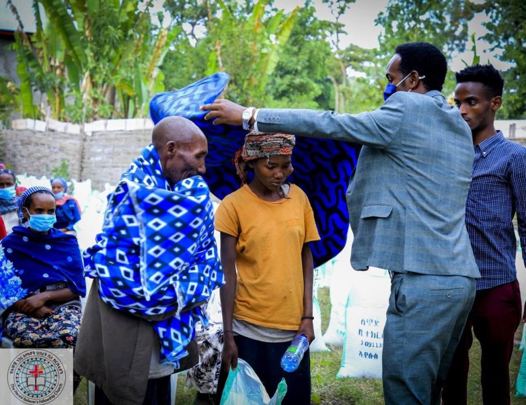 Several people receiving blankets and food after the service.